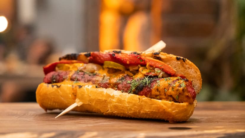 Hot dog gourmet con queso y aderezo de mostaza.