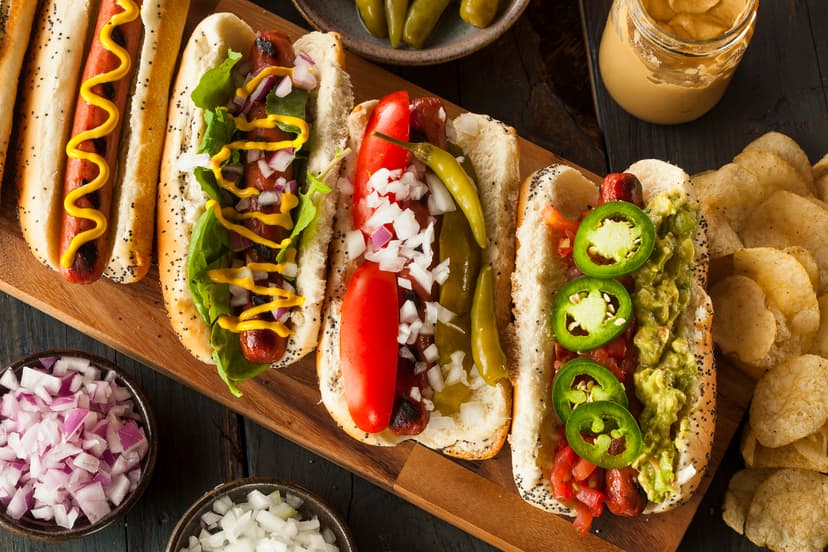 Hot dogs de diferentes estilos con aderezos y verduras
