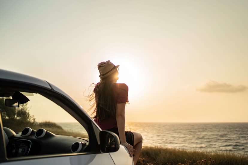 Mujer mirando el atardecer en carretera
